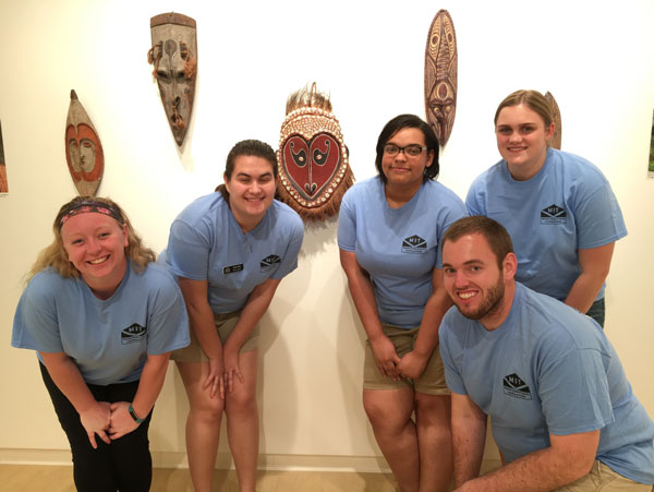 Museum Studies students pose with their exhibition "Olpela: Artifacts from Papua New Guinea"