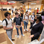 Students admire a poster presentation during the student scholar showcase