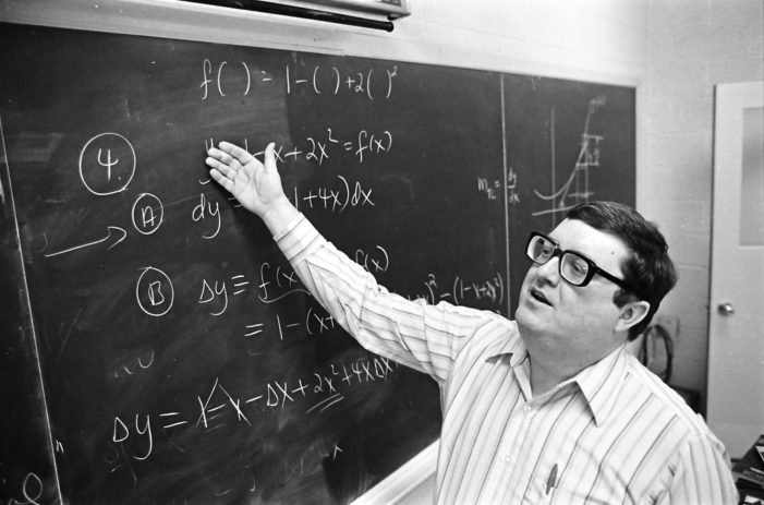 Dr. Tom Nicely points to equations drawn on a chalk board